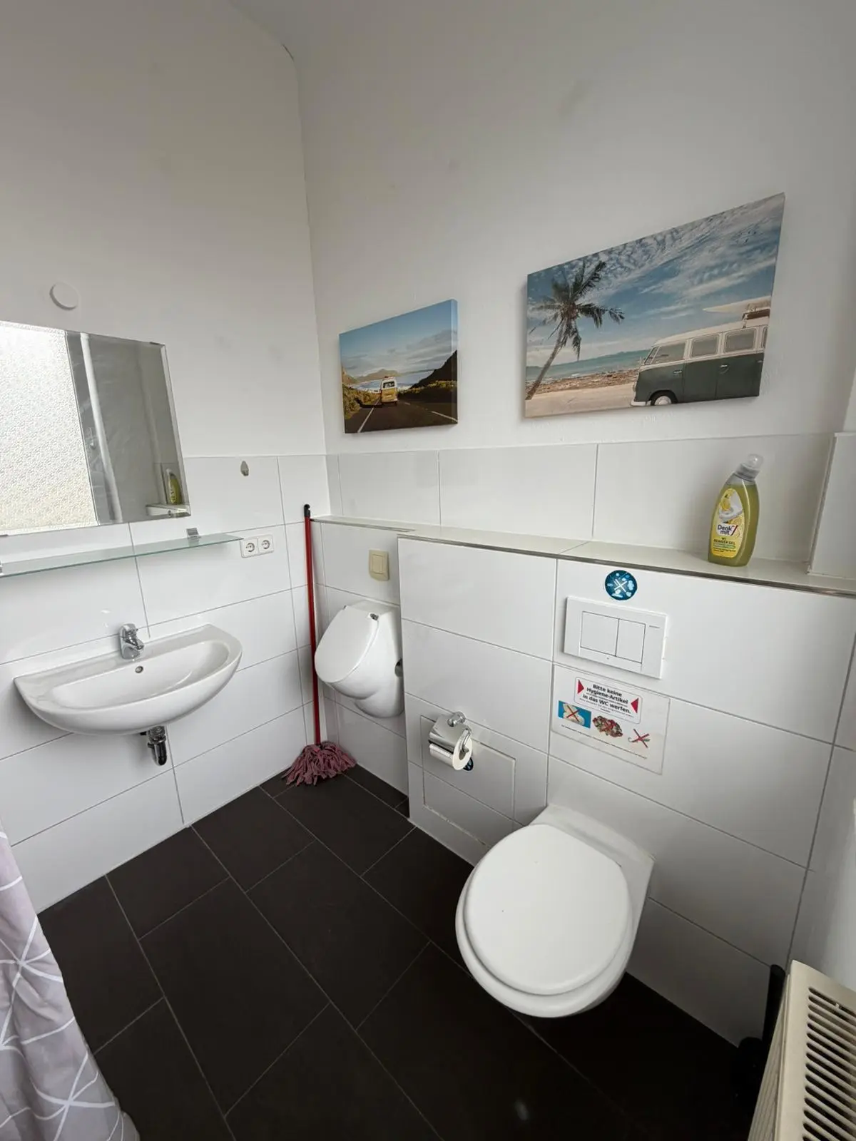 Sauberes Badezimmer mit WC, Urinal und Waschbecken in einer Monteurwohnung in Geislingen.