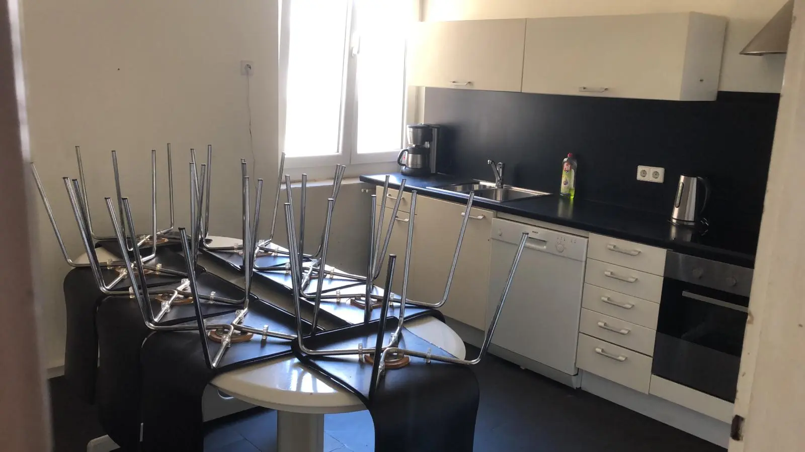 Helle, saubere Küche in einer Unterkunft für Monteure in Geislingen mit Spülmaschine, Kaffeemaschine und großem Esstisch.