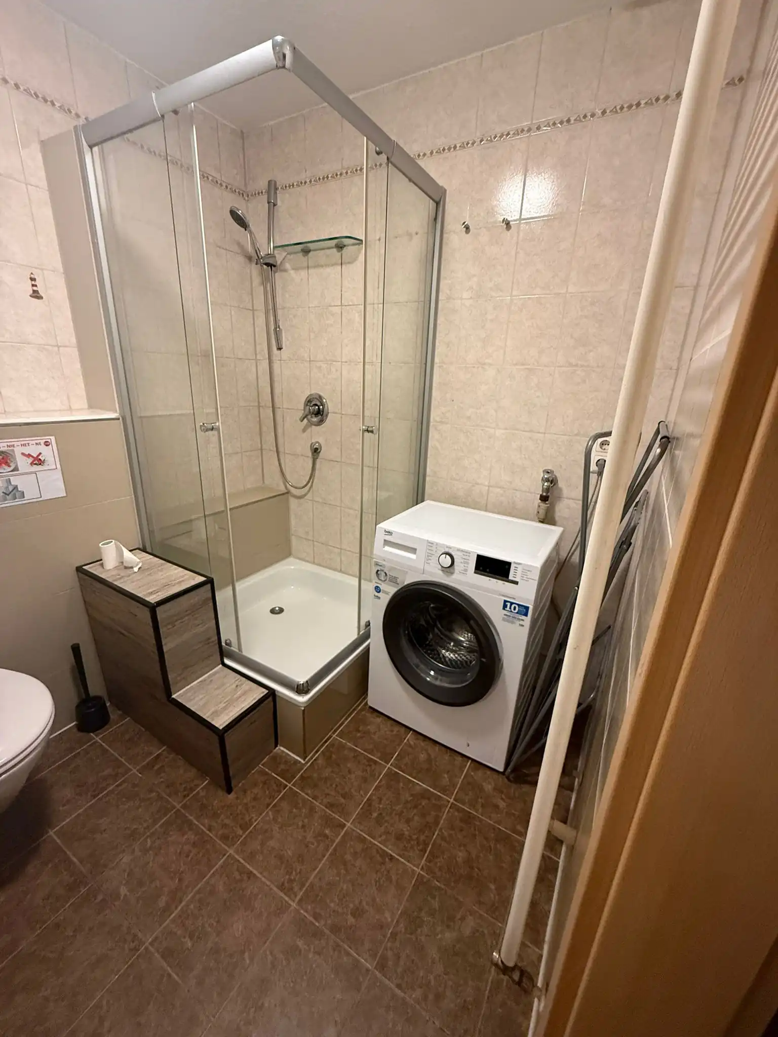Modernes Badezimmer mit Dusche und voll funktionsfähiger Waschmaschine für Gäste in einem Monteurzimmer in Geislingen an der Steige.