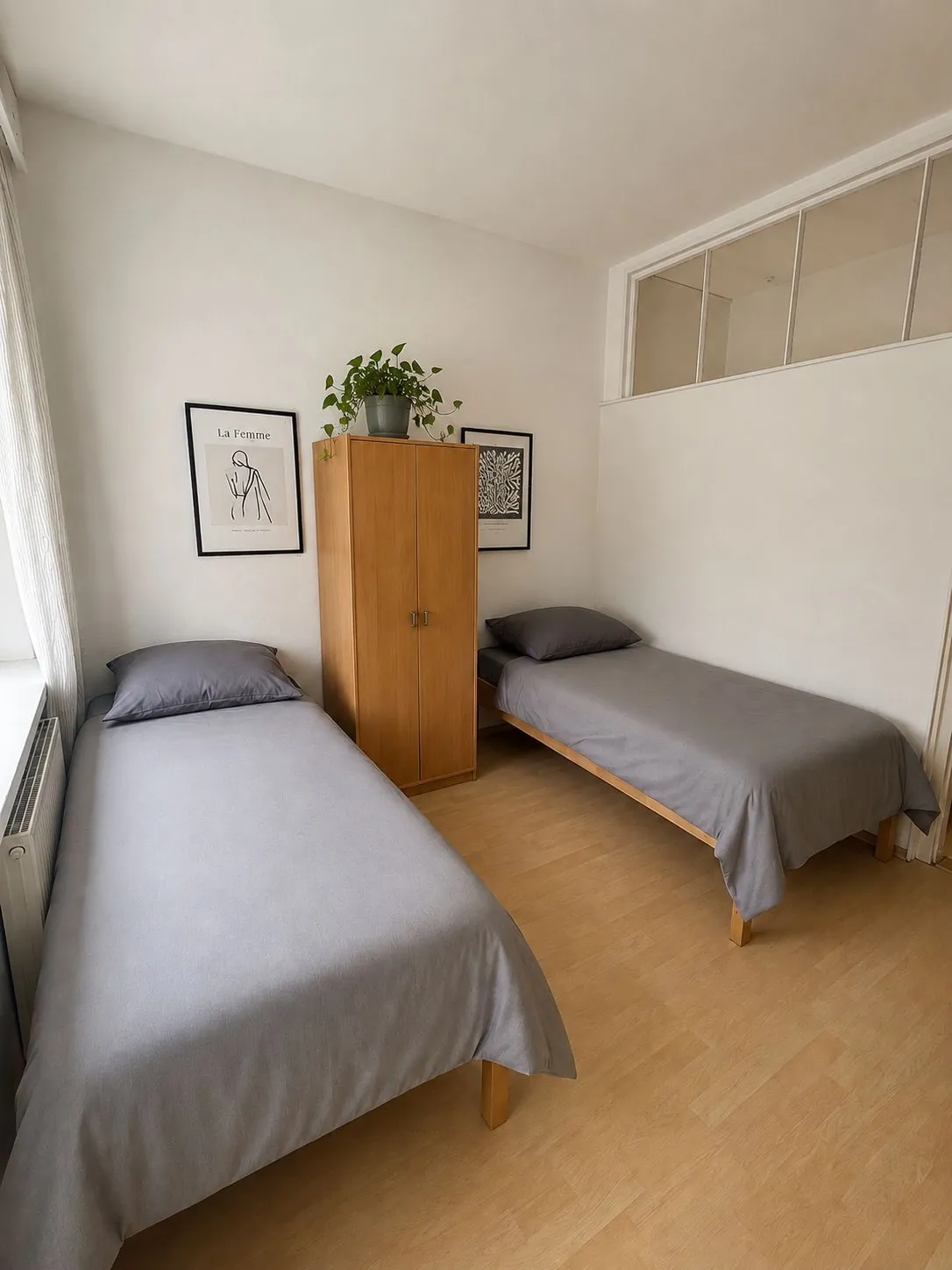 Gemütliches Zweibettzimmer mit zwei Einzelbetten, Schrank und Dekoration für komfortables Wohnen auf Zeit in Geislingen.