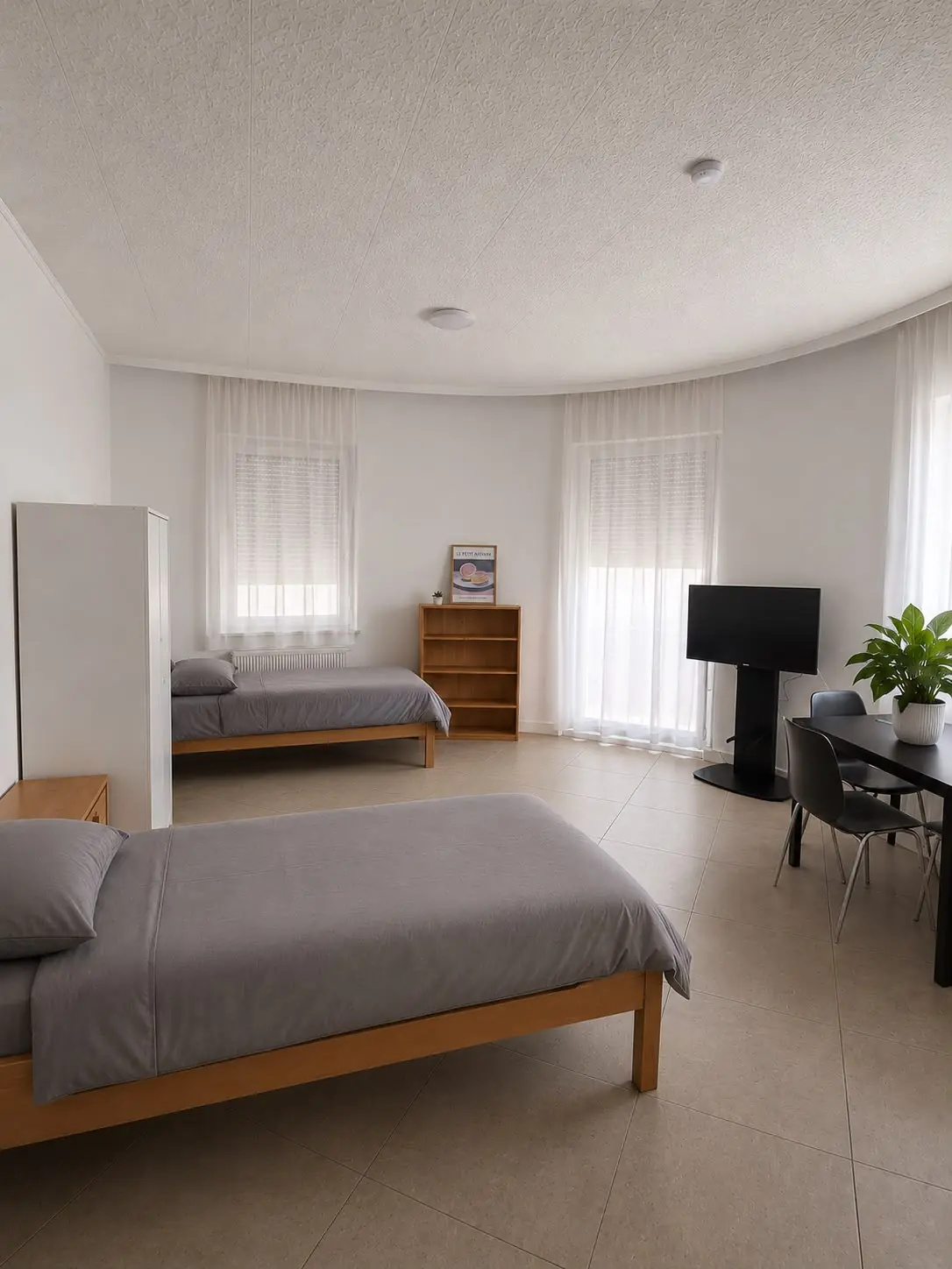 Zweibettzimmer mit zwei Einzelbetten, Schreibtisch und Fenstern in heller Monteurwohnung